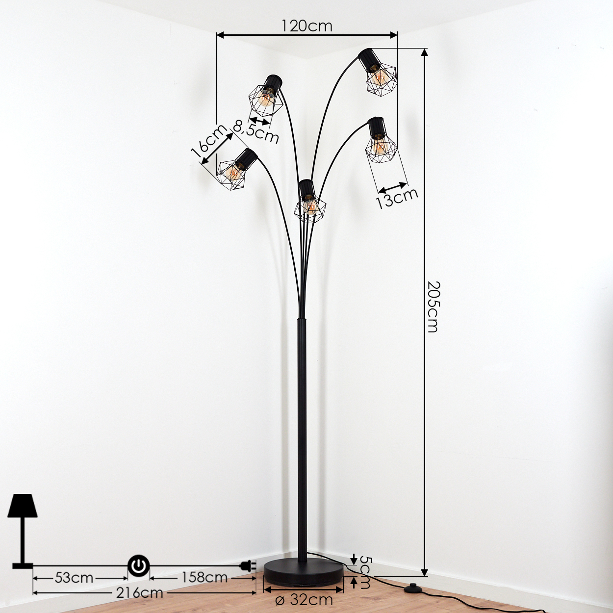 Eine schwarze mehrköpfige Stehlampe mit fünf freiliegenden Edison-Glühbirnen in Drahtkäfigen, mit Maßen vor einer weißen Ecke.