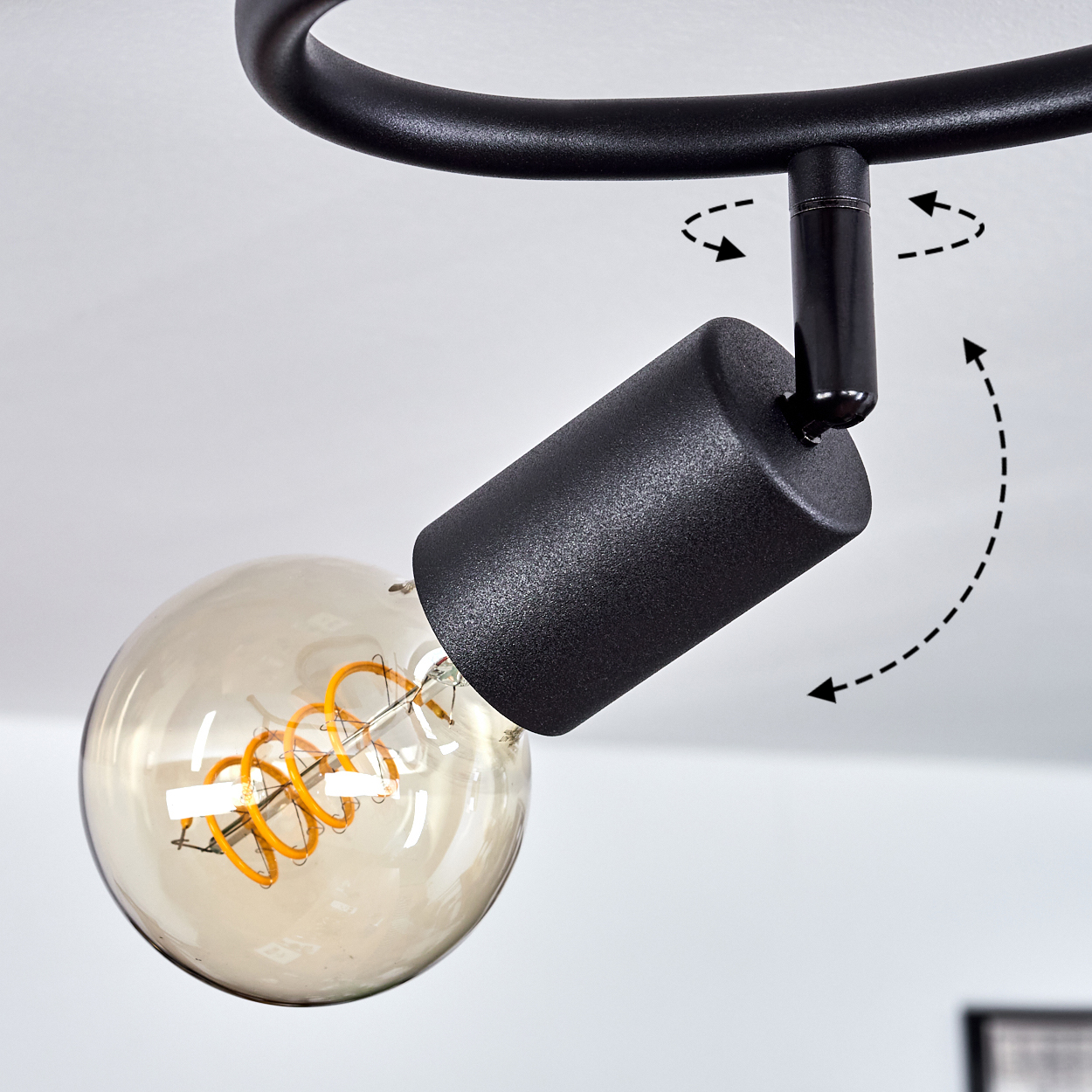 Schwarzer Deckenstrahler mit drehbarem Gelenk und sichtbarer Edison-Glühbirne.