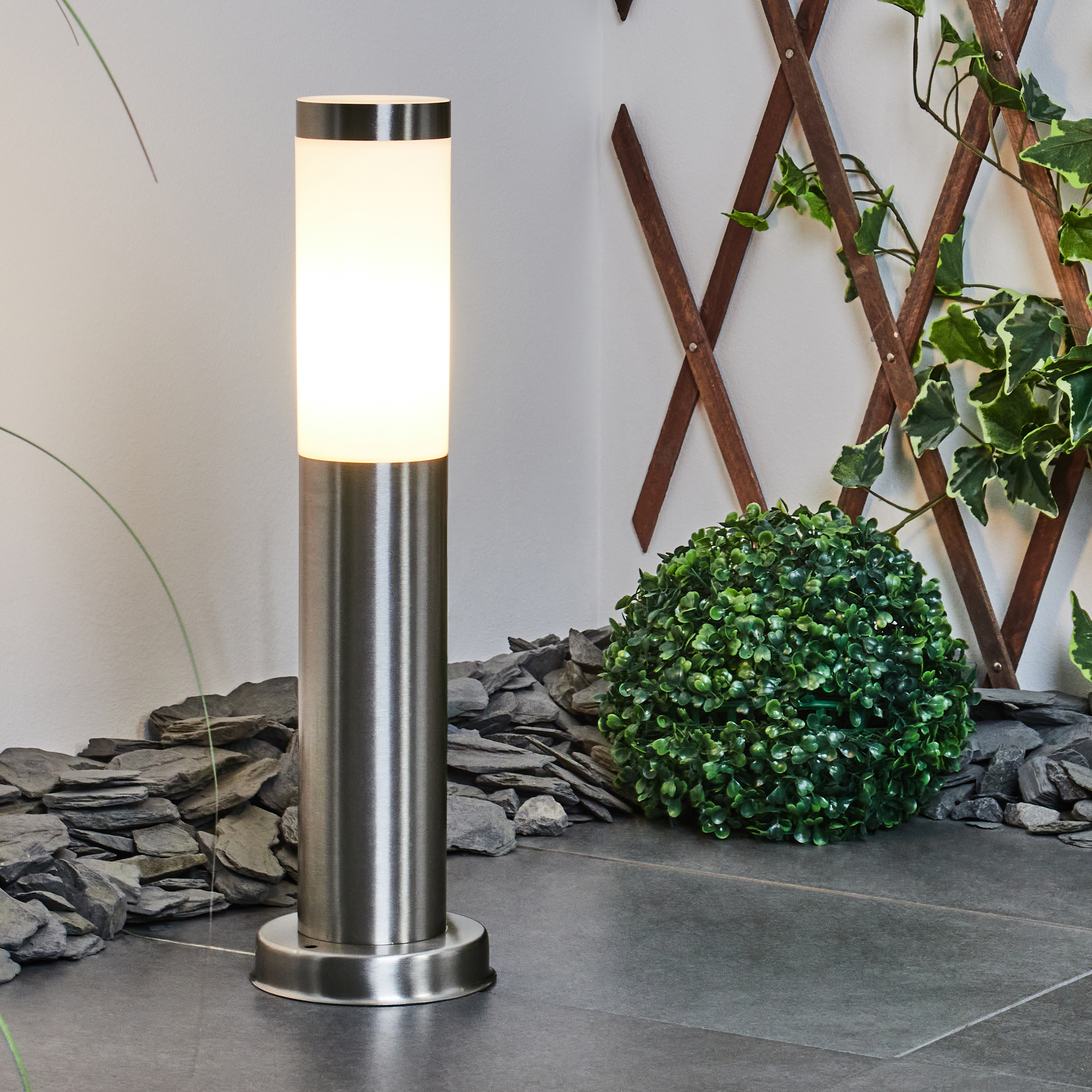 Ein zylindrischer polierter Metallpfosten mit beleuchtetem weißem Glas oben.