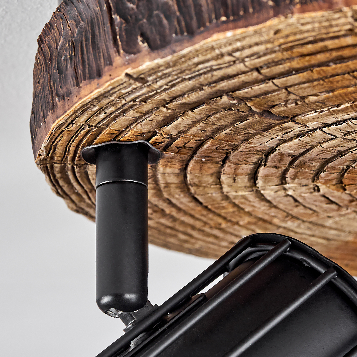 Nahaufnahme eines Holzelements mit schwarzen Metallbefestigungen.