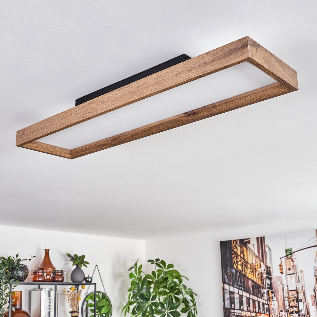 Eine rechteckige Deckenleuchte mit Holzrahmen und weißem Diffusor leuchtet.