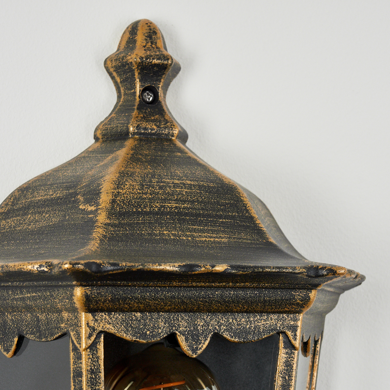 Eine Nahaufnahme einer schwarzen und goldenen Wandleuchte im viktorianischen Stil.