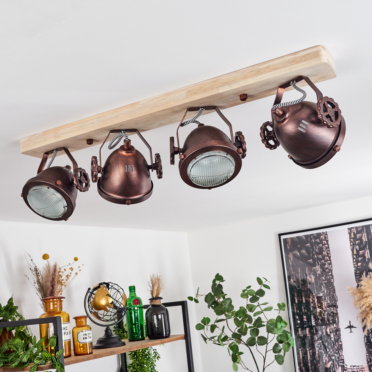 Deckenleuchte mit vier kupferfarbenen Spots auf einem Holzbrett.