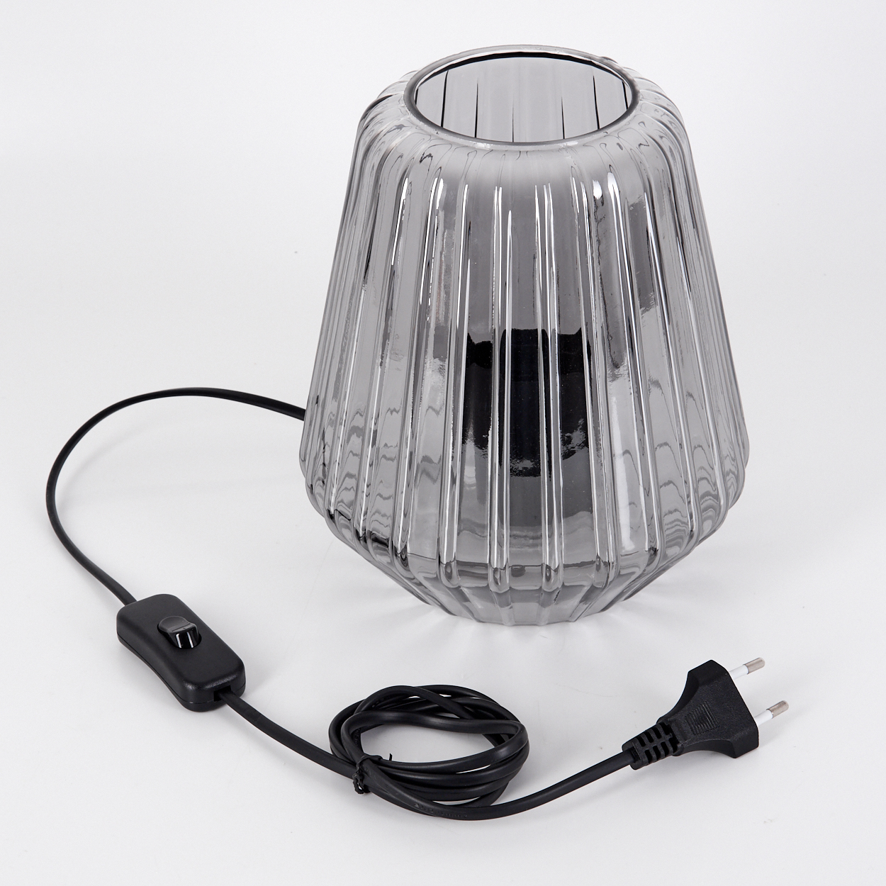Graue Glaslampe mit vertikalen Rillen, schwarzem Kabel und Stecker.