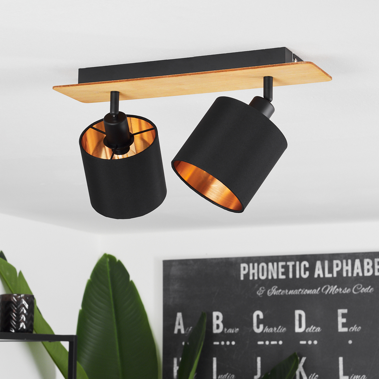 Schwarze Pendelleuchte mit Holzdetail und kupferfarbenem Innenleben.