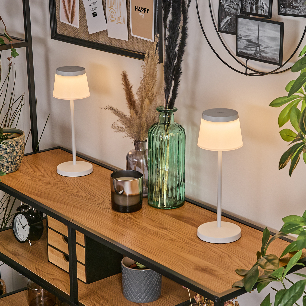Zwei weiße Lampen auf einem Holzregal mit Dekorationen wie Vasen und Pflanzen.