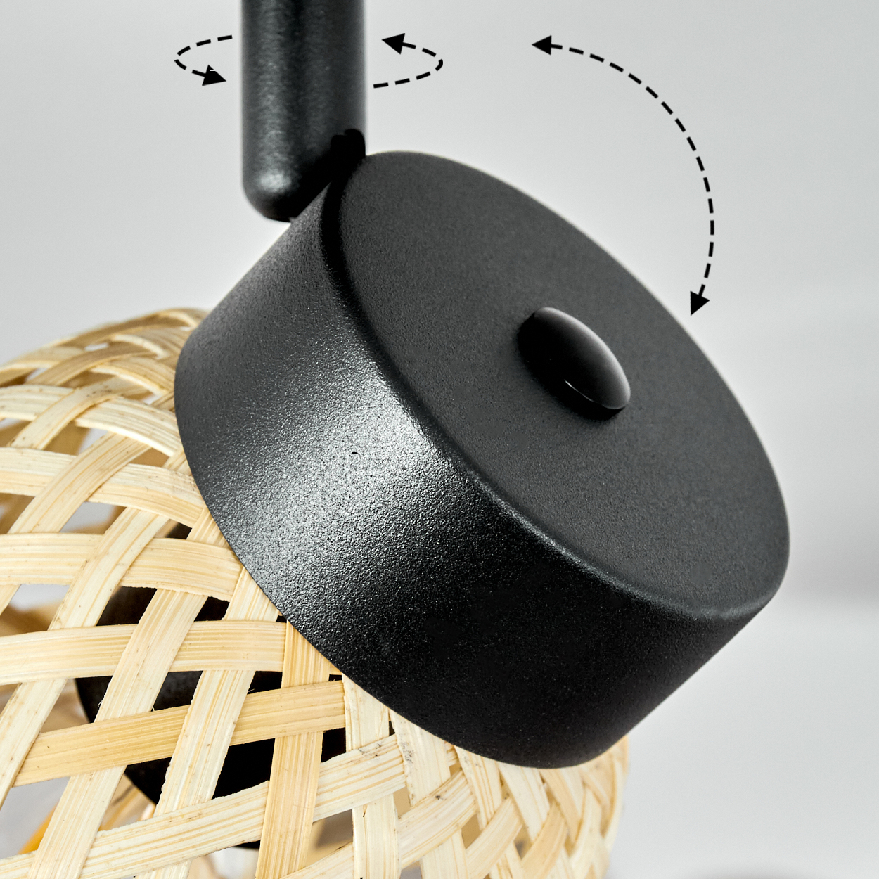 Nahaufnahme einer Lampe mit schwarzem Oberteil und Bambusgeflecht-Schirm. Pfeile zeigen Bewegung.