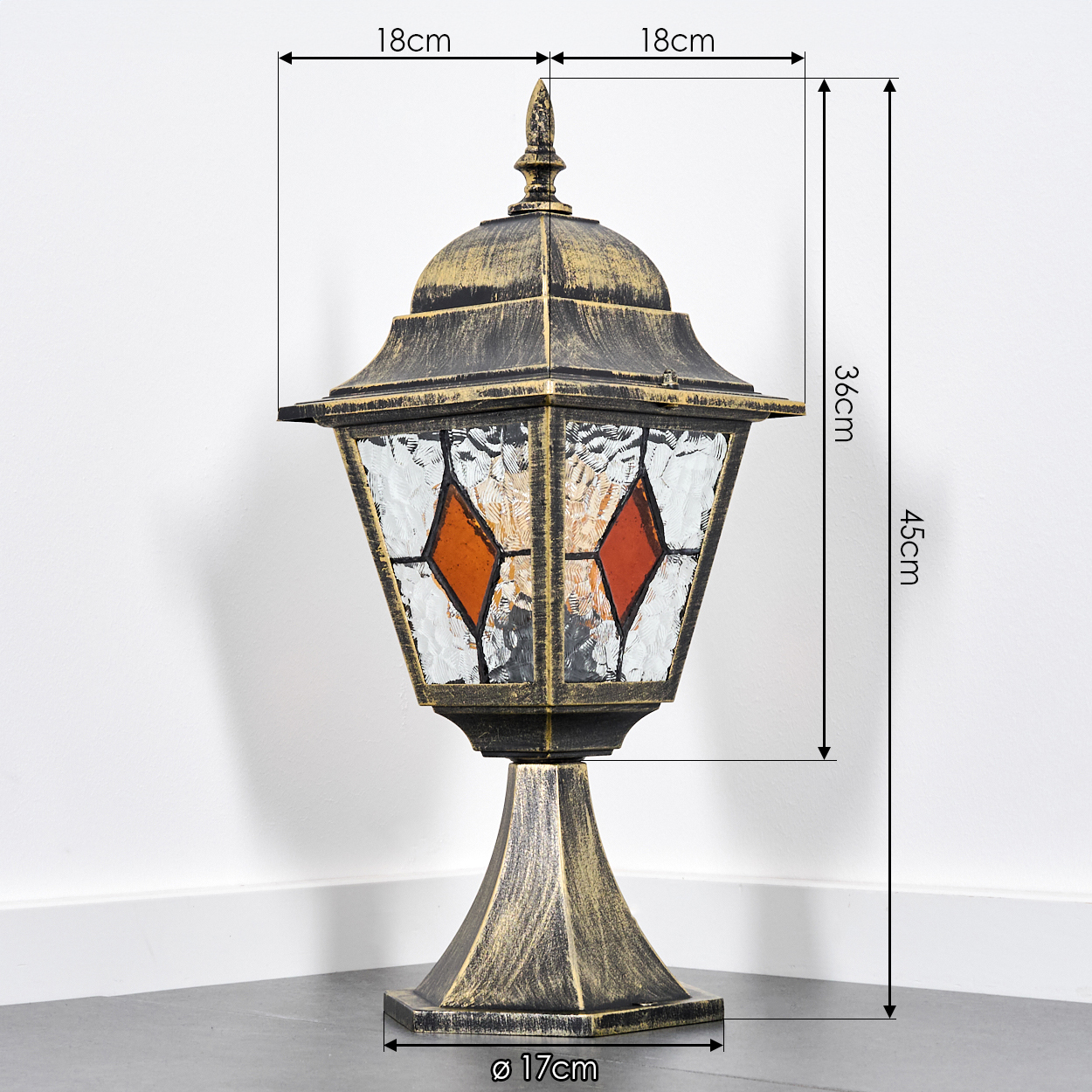 Eine antike Lampe mit Glasfenstern und orangefarbenen Rauten.