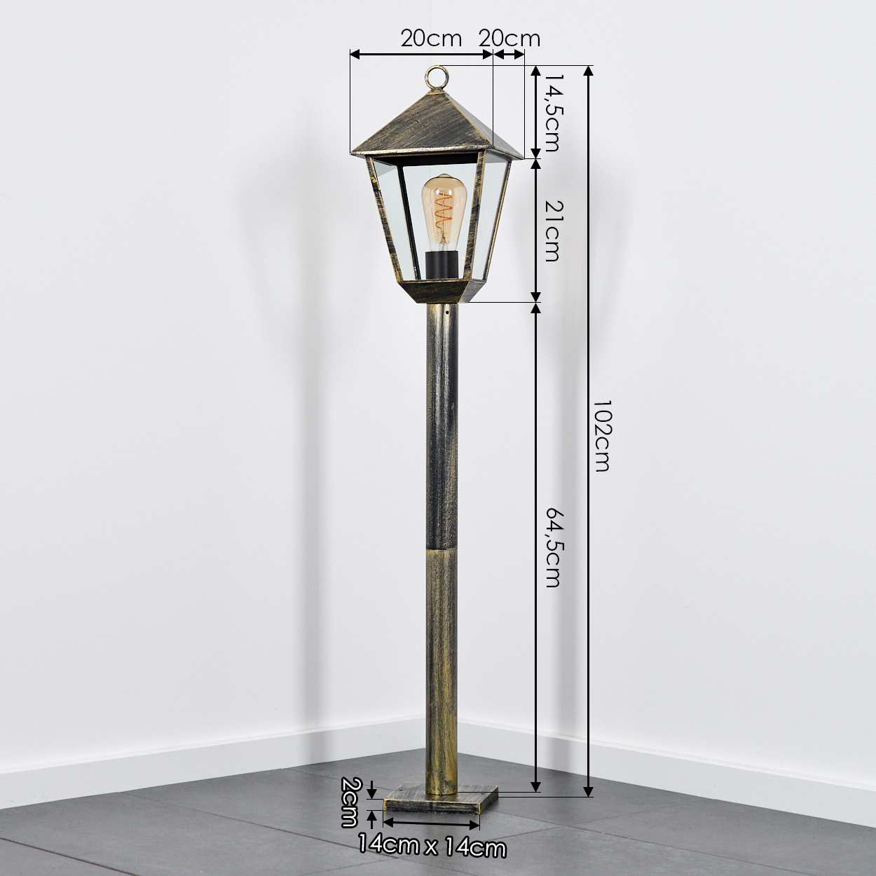 Eine antike Stehlampe mit Glühbirne, schwarzem Gestell und Messingdetails.