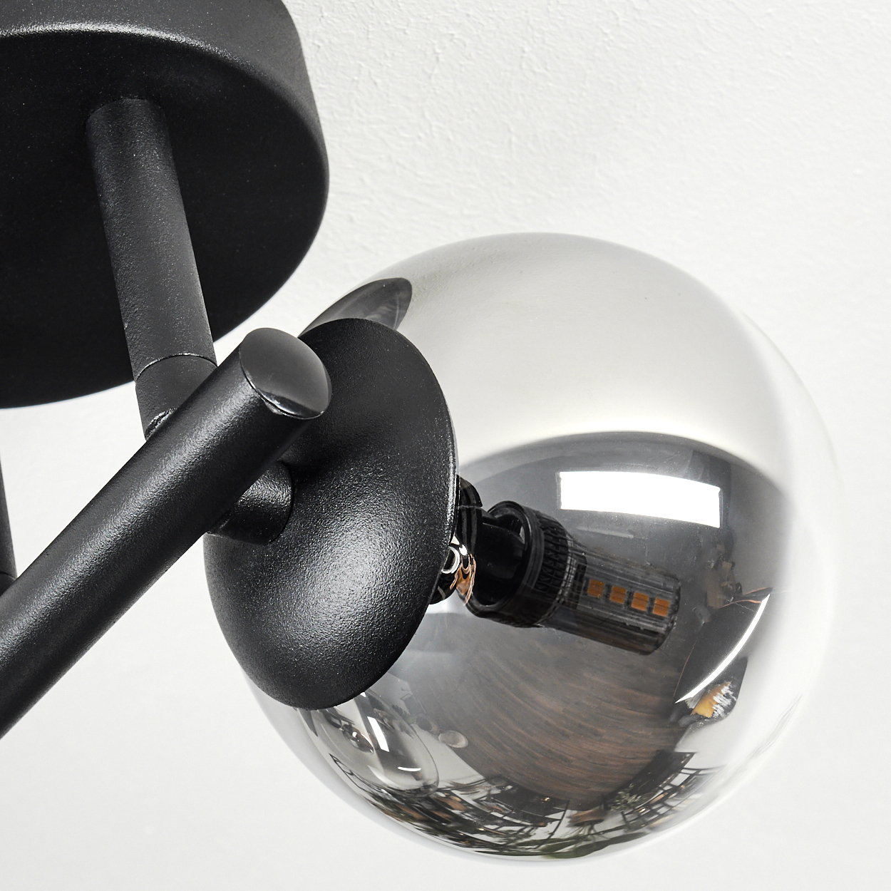 Nahaufnahme einer schwarzen Lampe mit einem rauchfarbenen Glaskolben, der eine LED zeigt.
