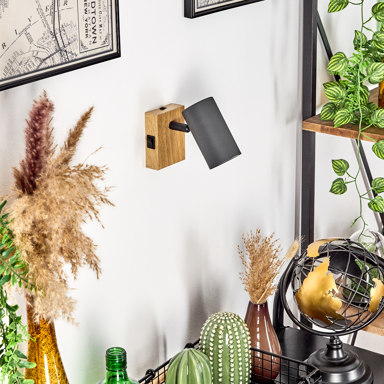 Wandleuchte aus Holz und Metall mit schwarzem Schirm, neben Trockenblumen.