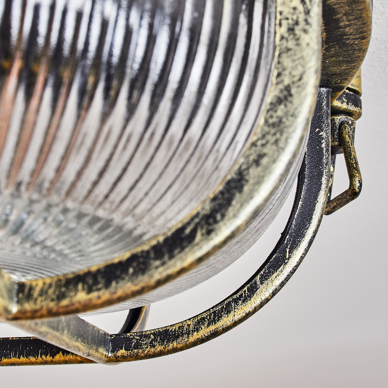 Detailaufnahme einer Vintage-Lampe mit geripptem Glas und gold-schwarzem Metallrahmen.