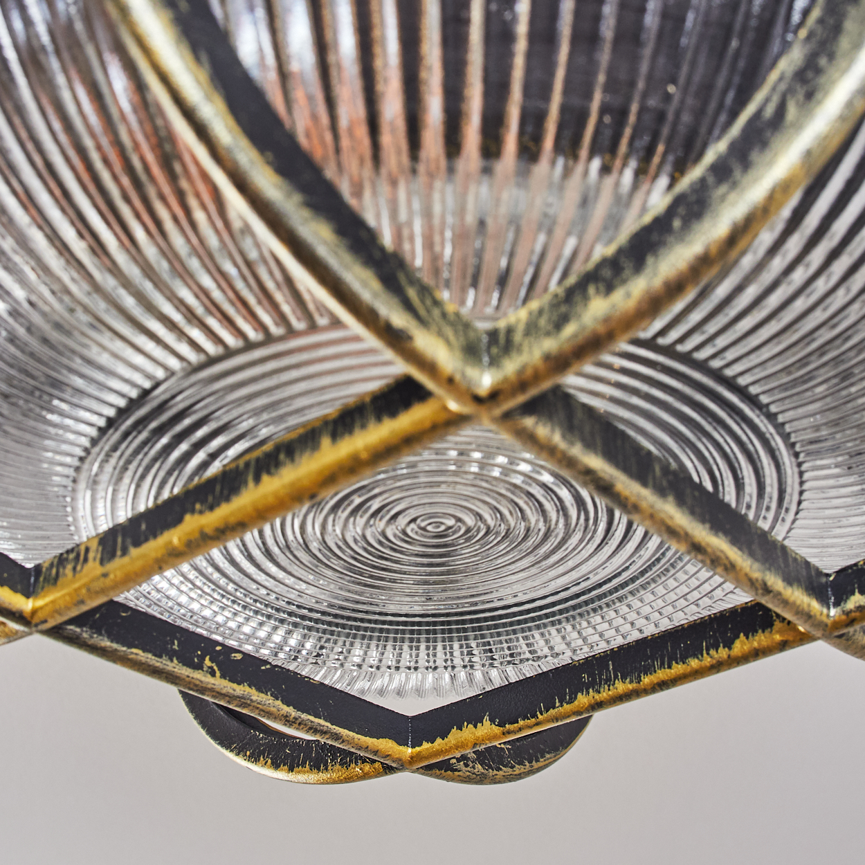 Nahaufnahme eines Glaslampenschirms mit Metallrahmen. Geriffeltes Glas mit konzentrischen Kreisen.