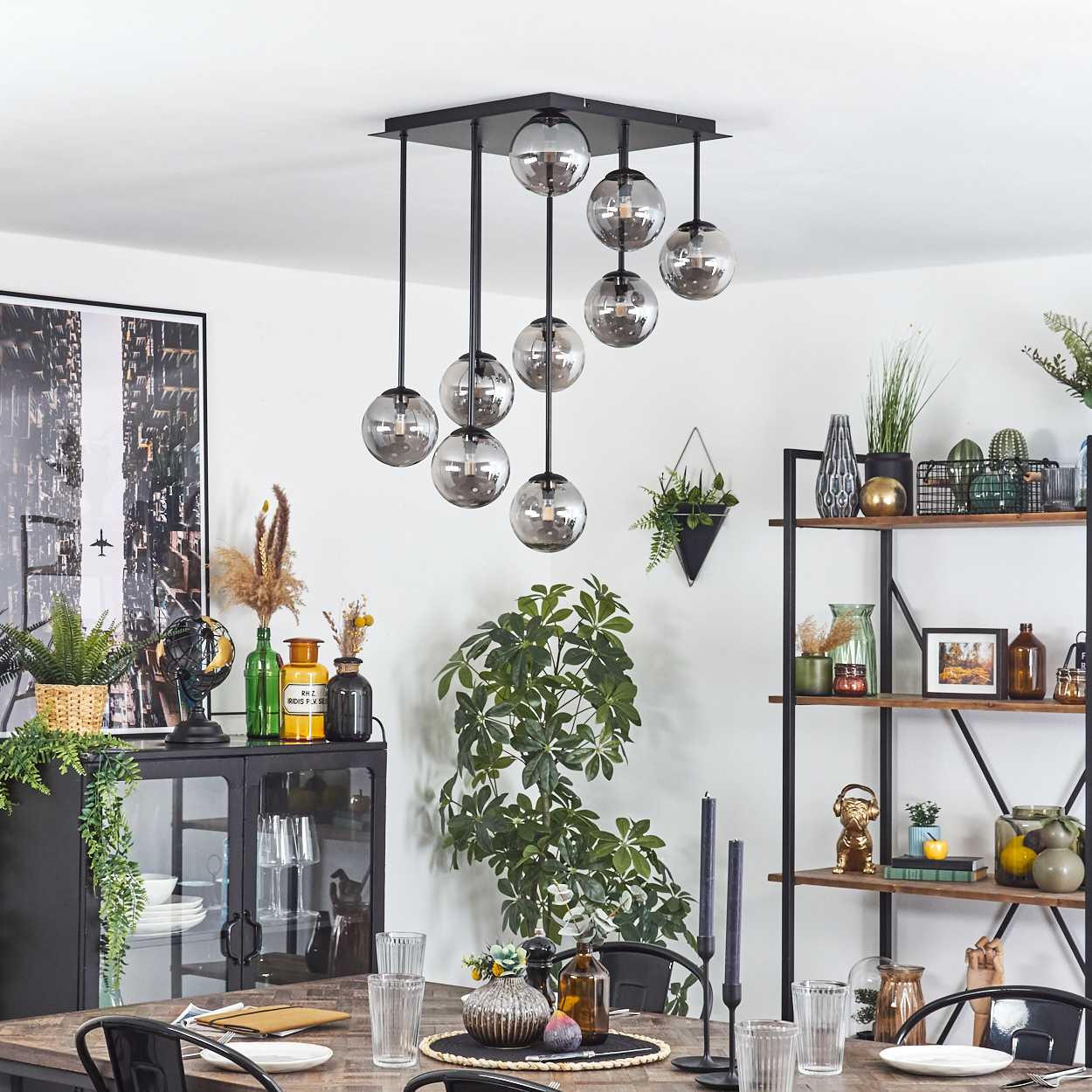 Ein Esszimmer mit einem Holztisch, Glaskugelleuchten und Regalen.