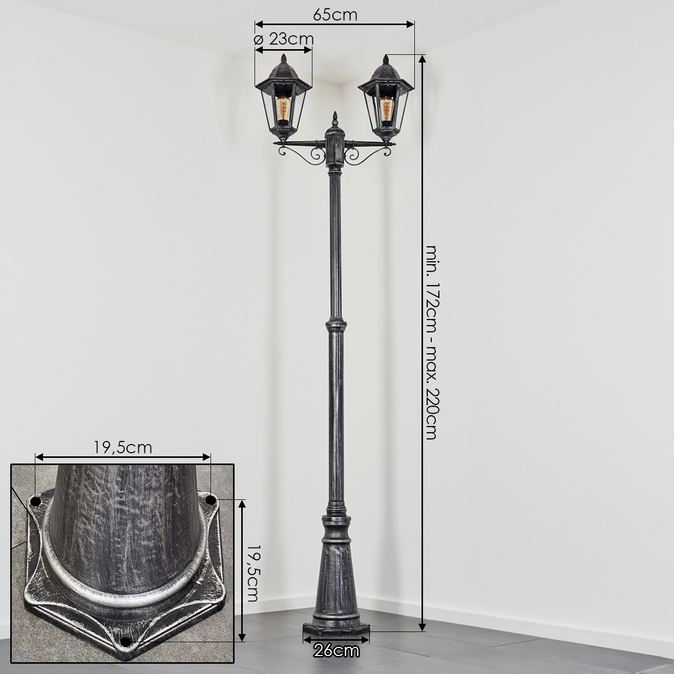 Ein zweilampiger Laternenpfahl mit dunklem Metall und Glühbirnen.