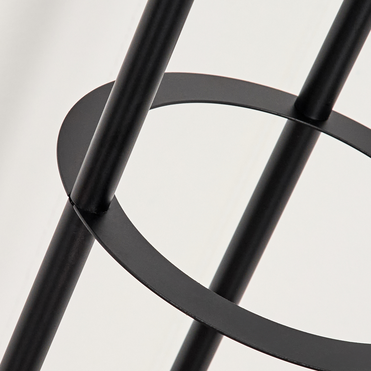 Schwarzer Metallrahmen mit drei vertikalen Stangen und einem horizontalen Ring.