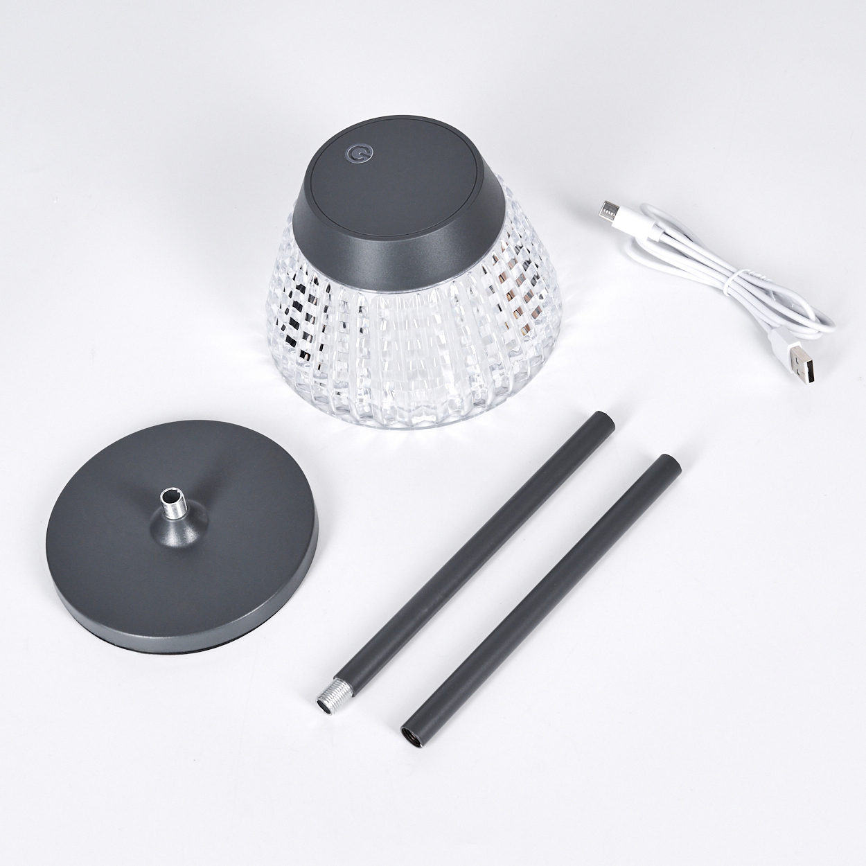 Lampe, Standfuß, zwei Stangen und USB-Kabel auf weißem Hintergrund.