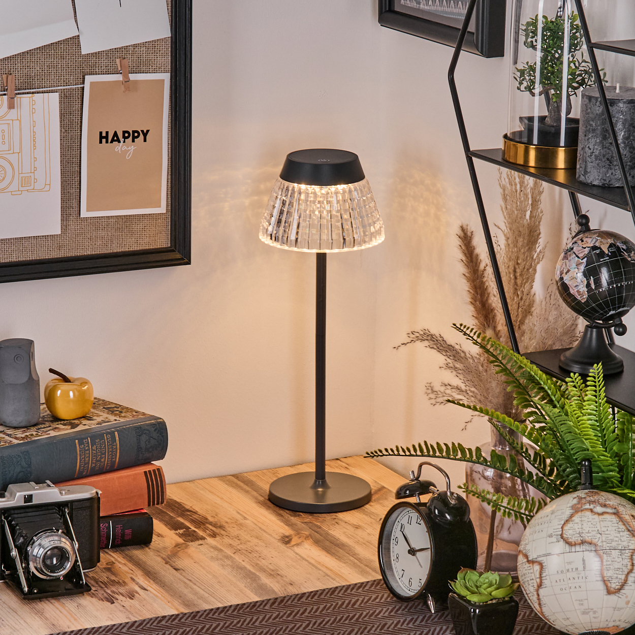 Ein Schreibtisch mit Lampe, Kamera, Büchern und Dekorationen.