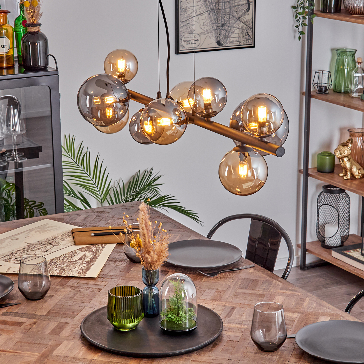 Ein moderner Kronleuchter mit bernsteinfarbenen Glaskugeln über einem Holztisch.