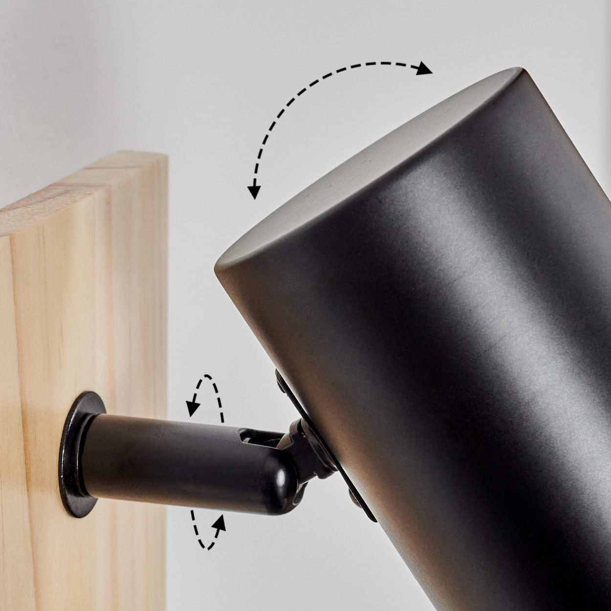 Ein schwarzer Lampenkopf ist an einem Holzbalken befestigt und verstellbar.