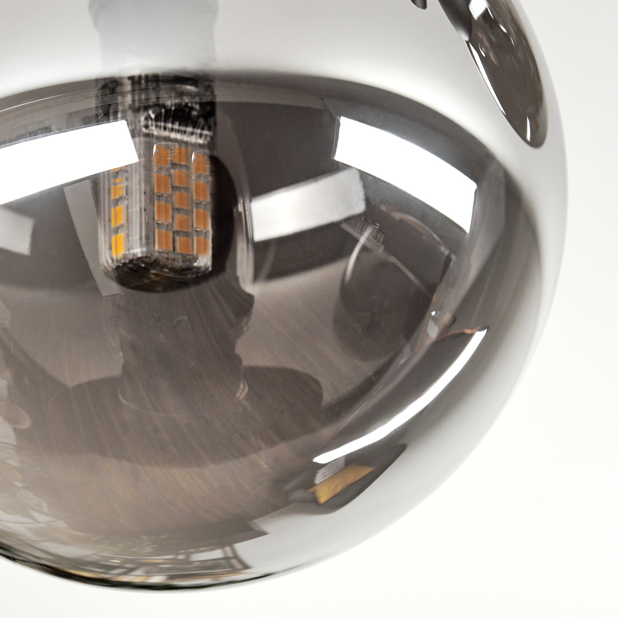 Nahaufnahme einer transparenten Glühbirne mit sichtbaren LED-Chips und Spiegelungen.