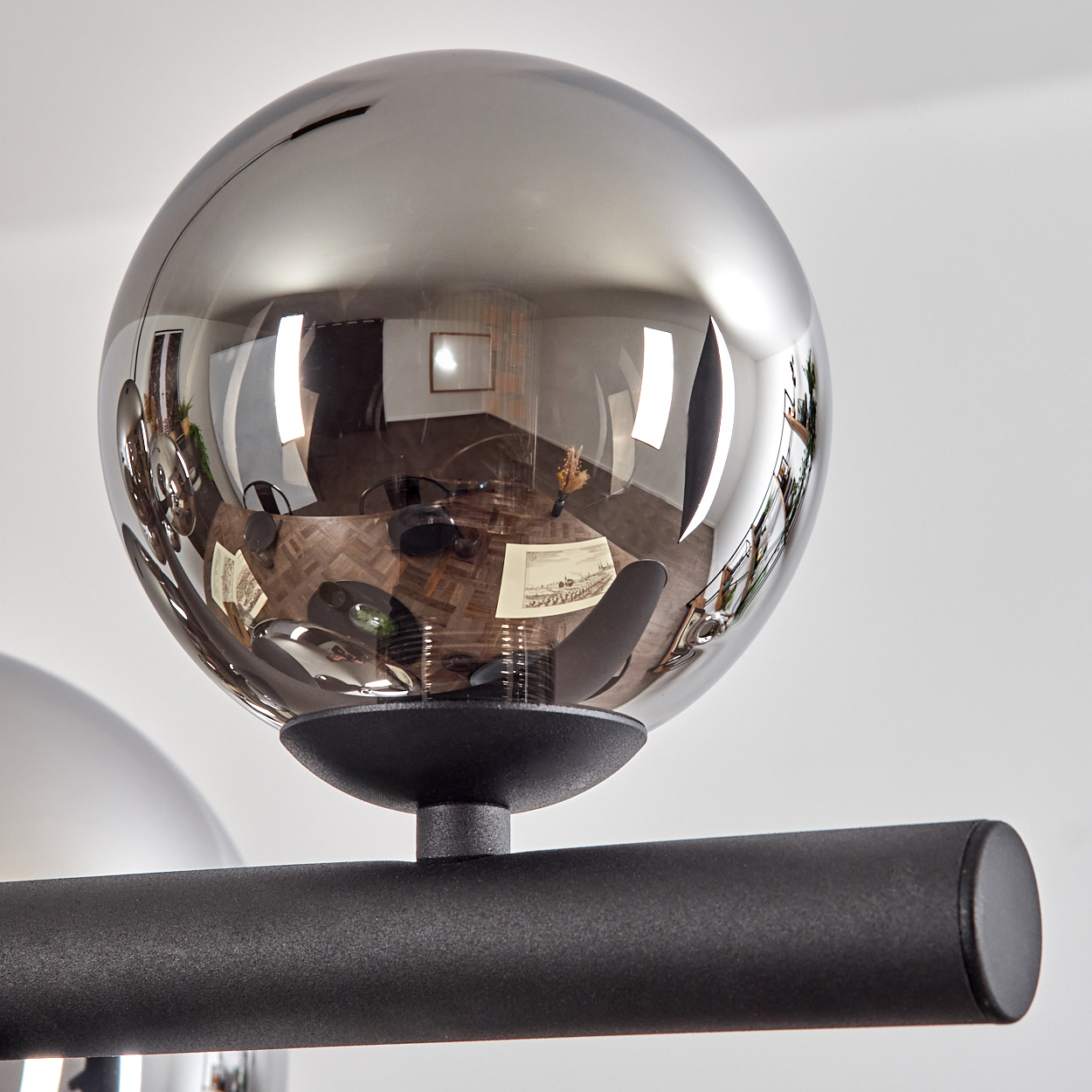 Eine spiegelnde Kugel reflektiert ein Esszimmer mit Holzboden.