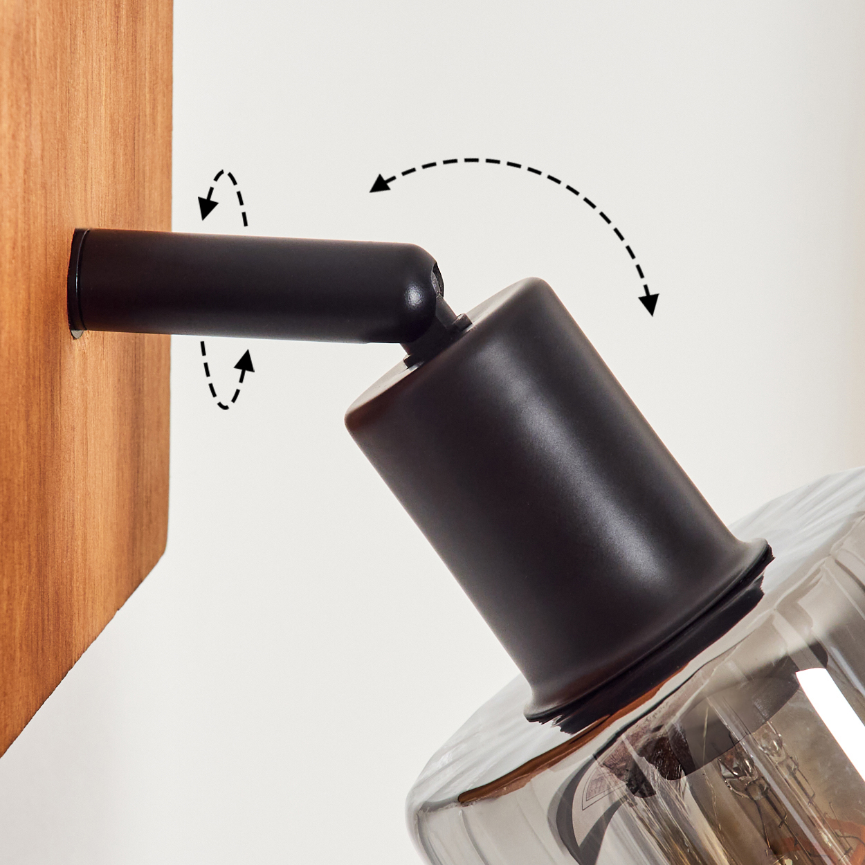 Ein schwarzer Lampenarm an Holzwand, verstellbar, mit Rauchglas-Schirm.