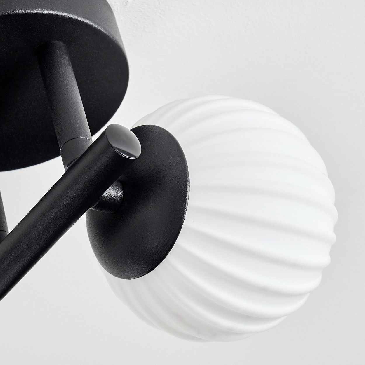 Schwarze Lampe mit verdrehtem weißem Lampenschirm auf weißem Hintergrund.