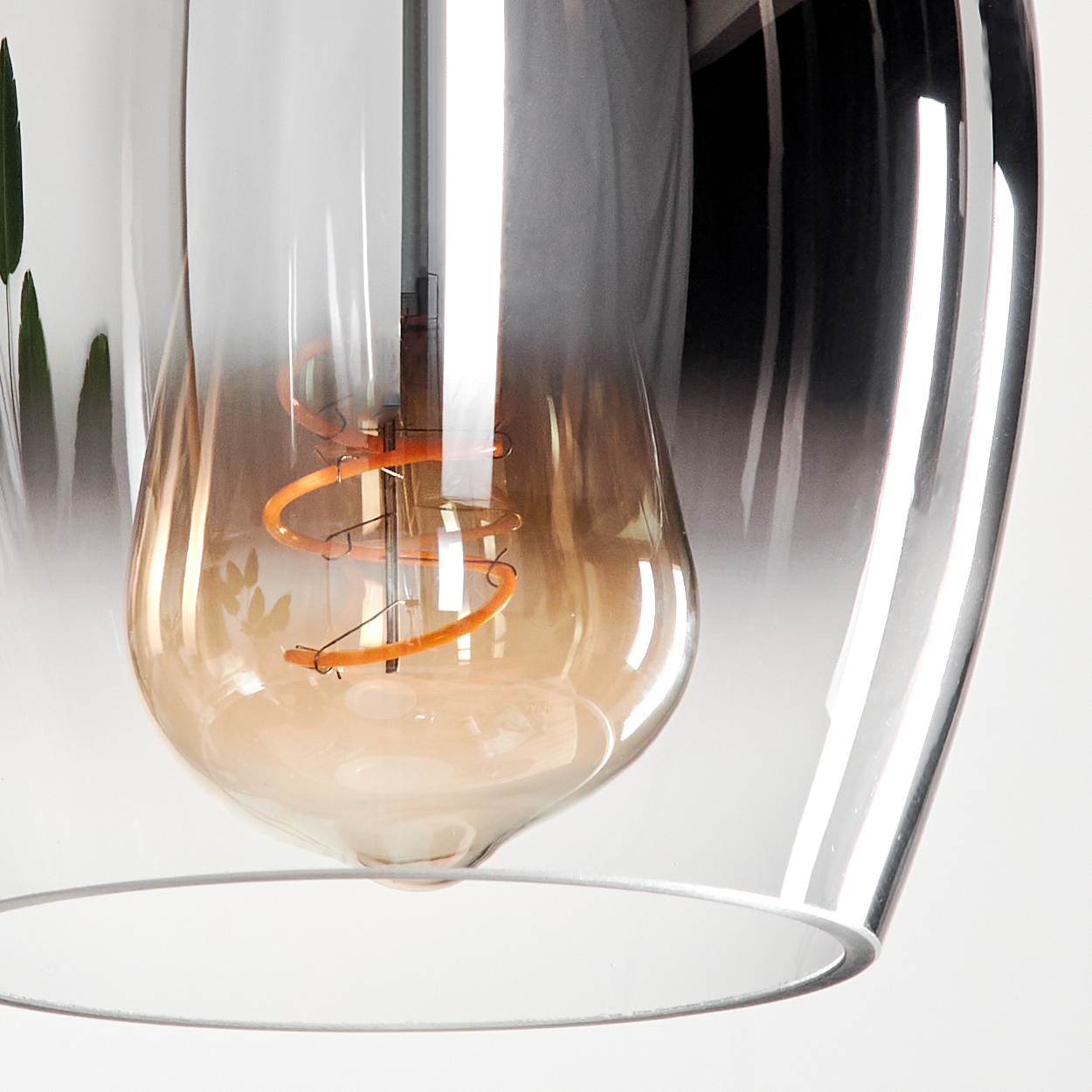 Naheaufnahme einer Glühbirne mit kupferfarbener Wendel und bernsteinfarbenem Glas.