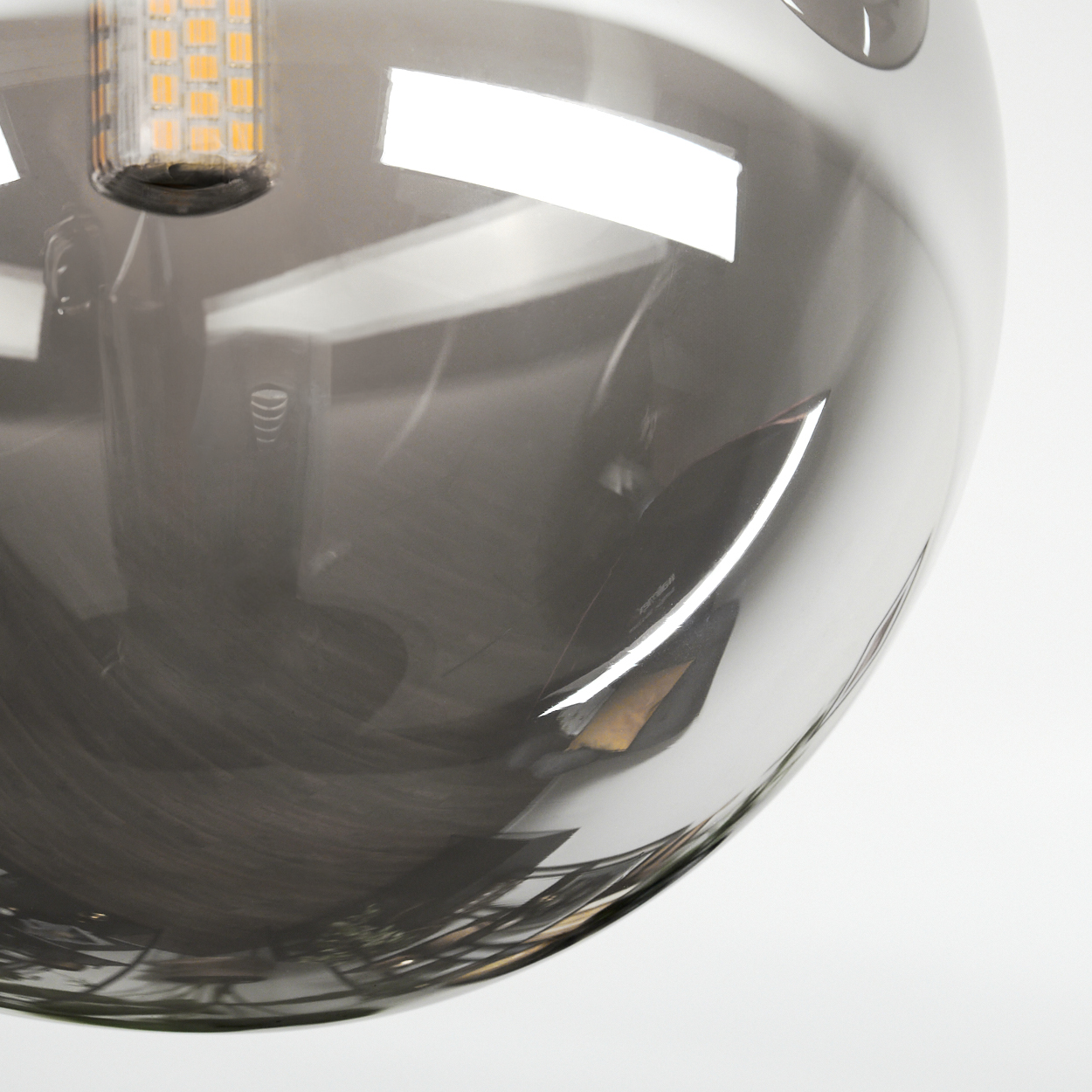 Nahaufnahme eines grauen, kugelförmigen Glasschirms mit einer LED-Birne darin.