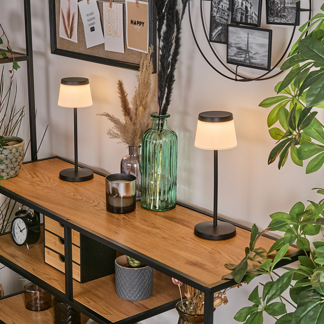 Zwei Tischlampen auf einem Holzregal neben Vasen und Pflanzen.