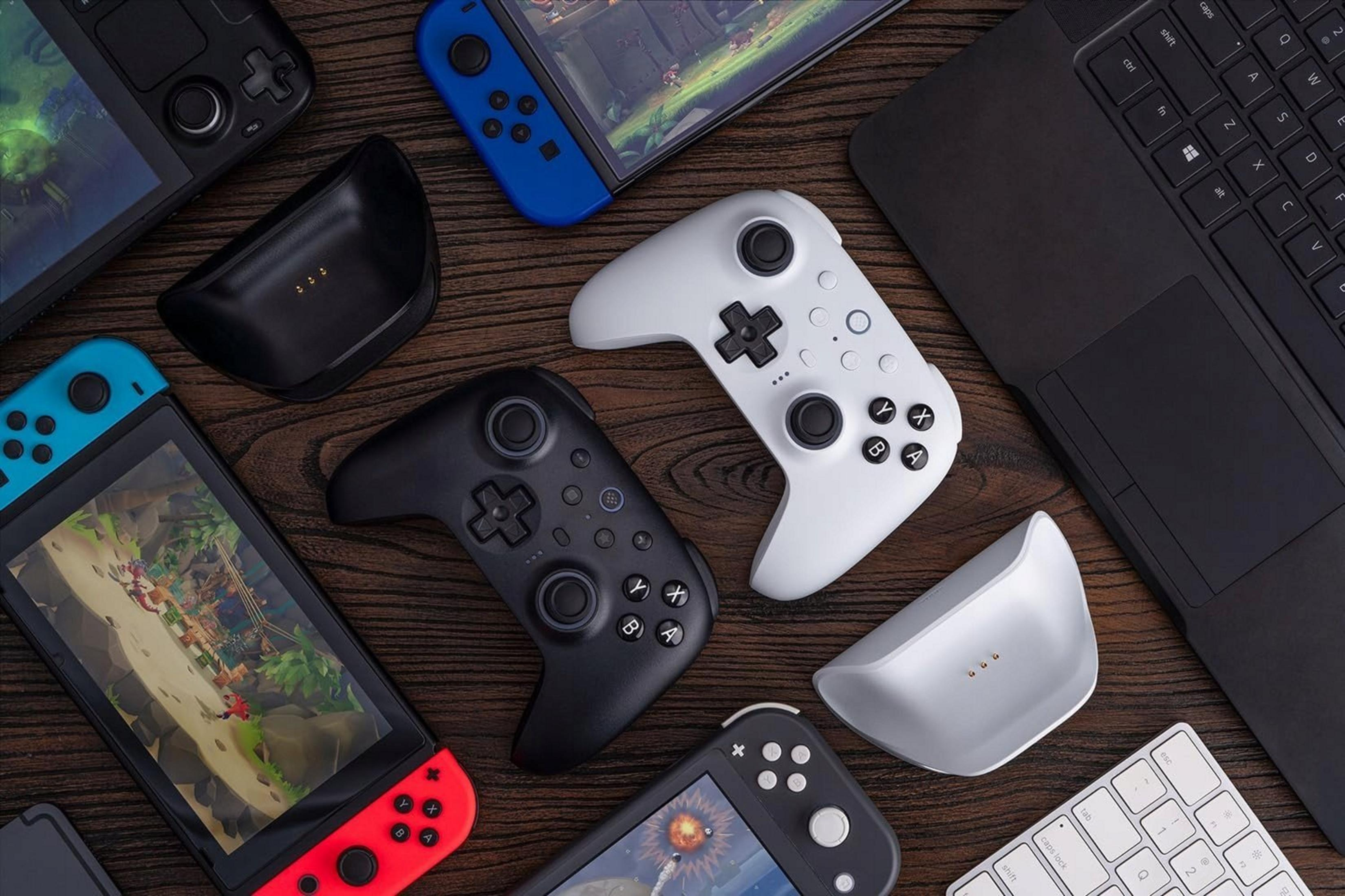 Gaming-Geräte: Controller, Laptops und Handhelds auf Holzoberfläche.