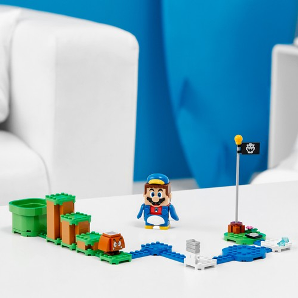 Figurine Mario, Goomba, obstacles et drapeau sur une table.