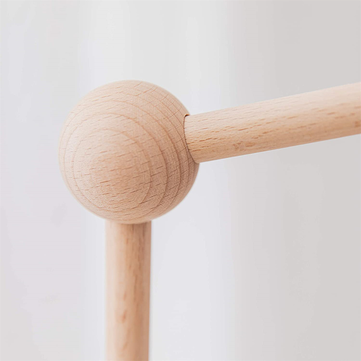 Holzkugel mit zwei Holzstangen, die sich in einem rechten Winkel treffen.