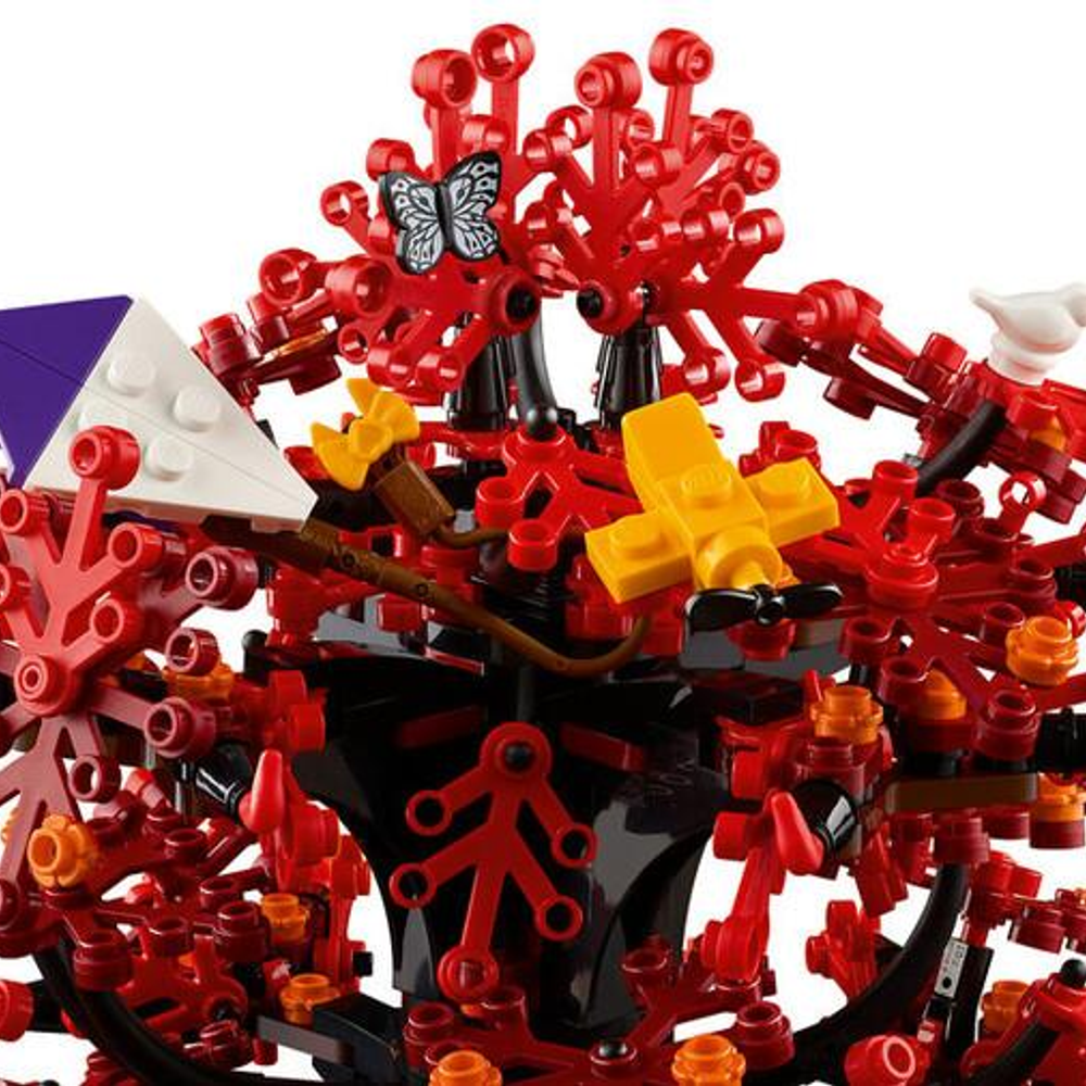 Een rode Lego-structuur met vlinder, geel vliegtuig, witte en paarse vormen.