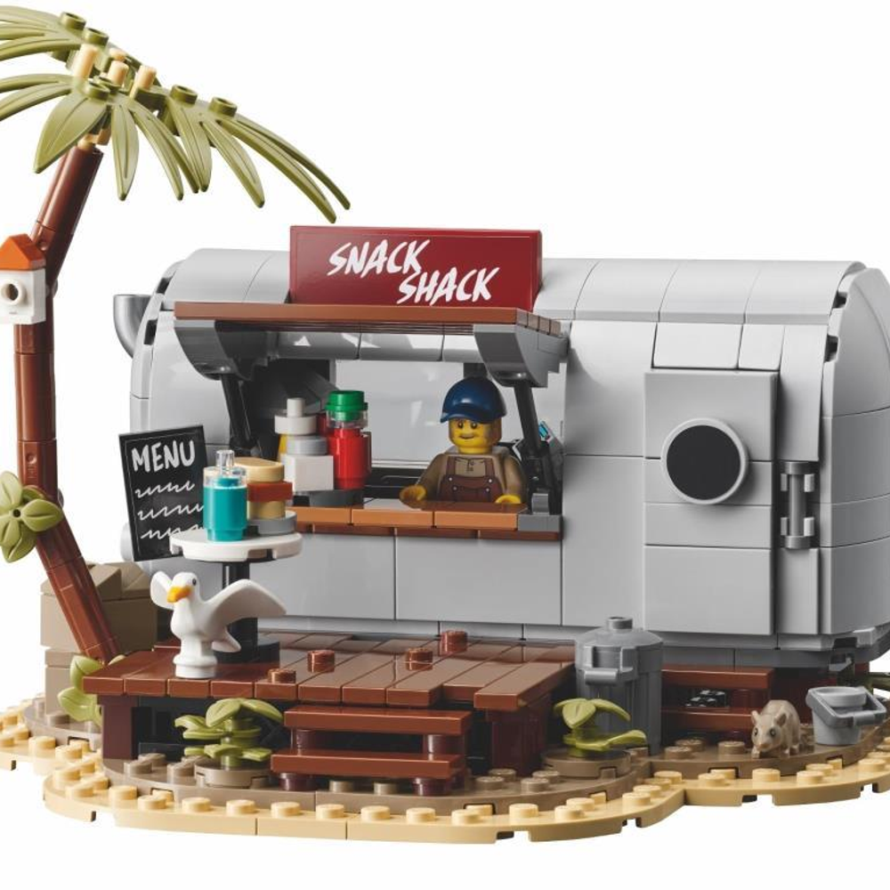 Stoisko z przekąskami Lego z palmami, stołami i figurką.