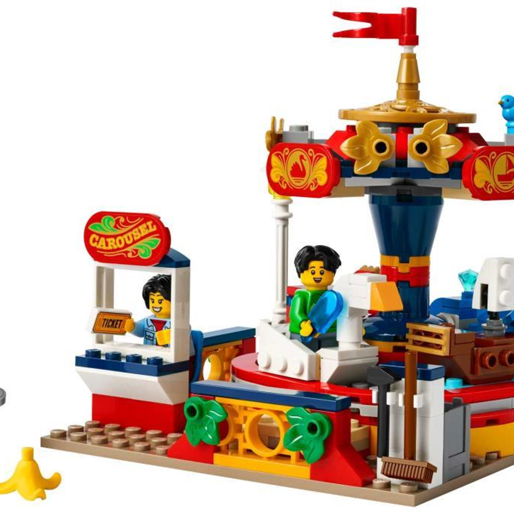 İki figür, bilet gişesi ve sarı muz içeren bir Lego atlıkarınca.