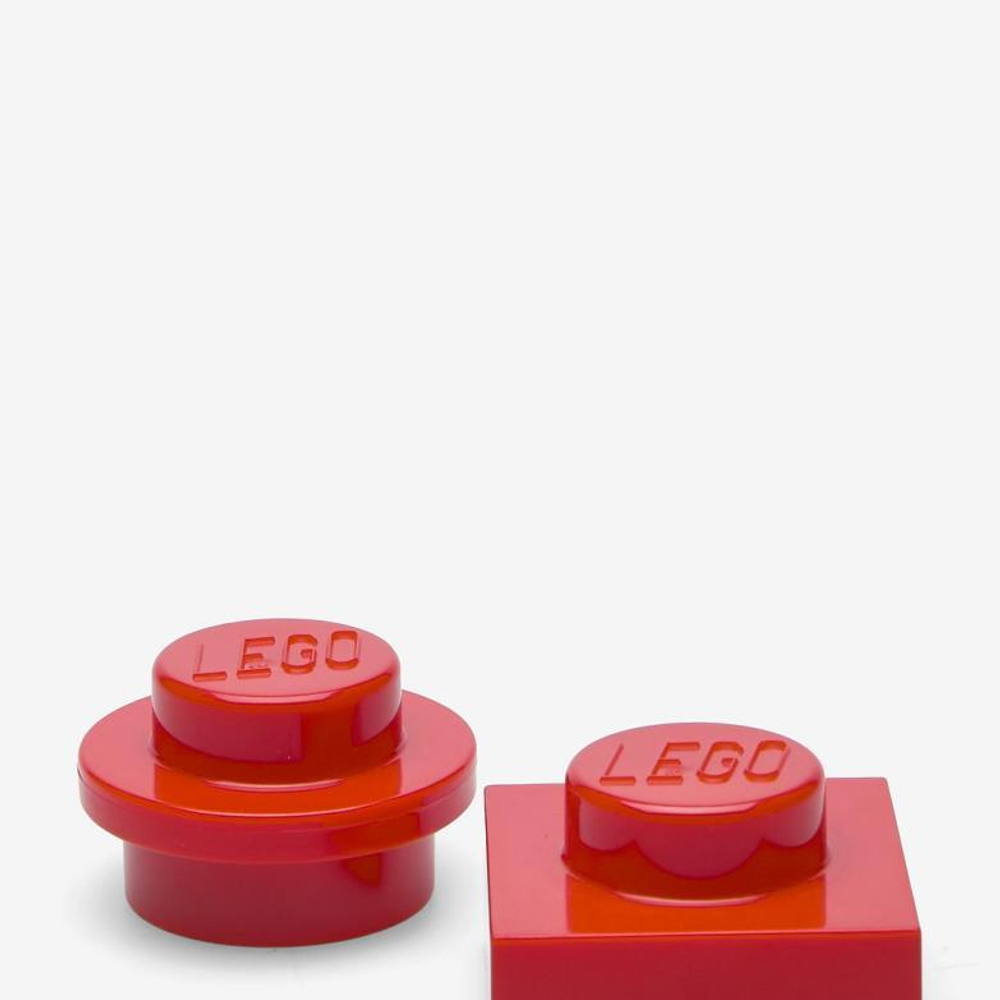 Due mattoncini LEGO rossi, uno tondo, uno quadrato, con logo LEGO.