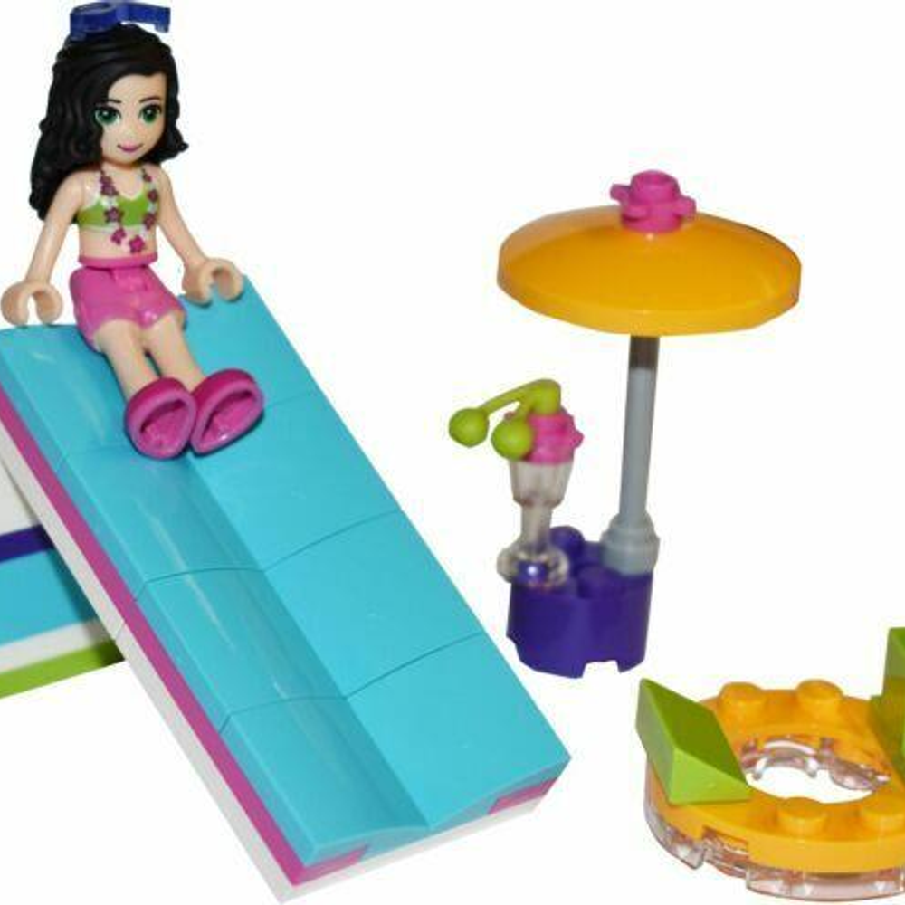 Una bambina Lego seduta su uno scivolo blu con ombrellone e lampada.