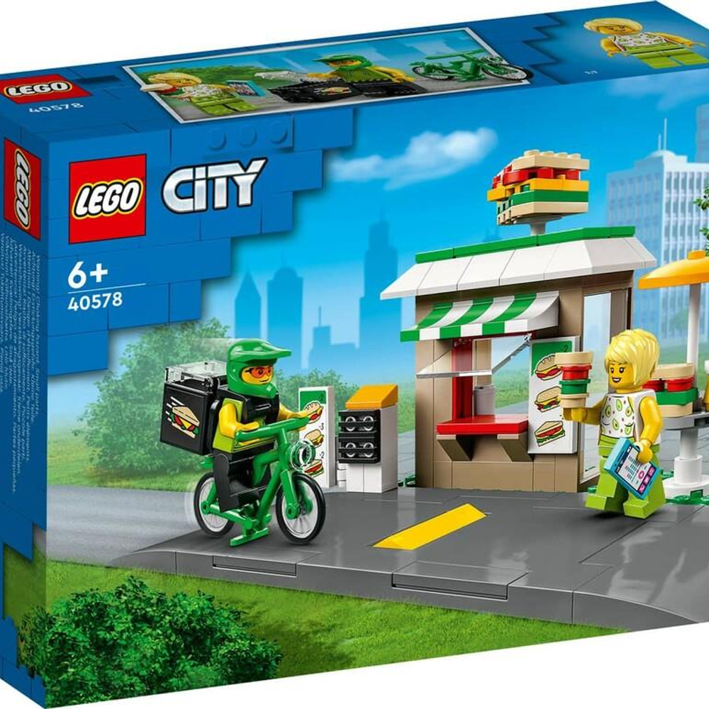 Bir Lego bisikletli kurye, bekleyen bir müşteriye büfeye yiyecek teslim ediyor.