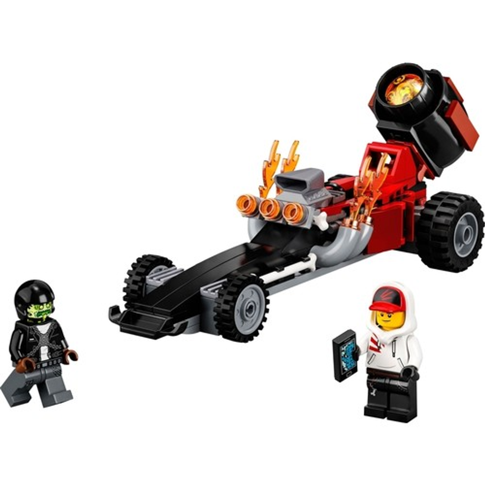 Kasklı yeşil Lego figürü, alevli kırmızı dragster ve telefonlu bir çocuğun yanında.