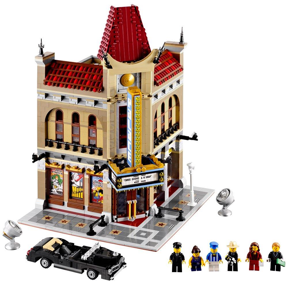 Bâtiment de cinéma Lego avec voiture et figurines. Un bâtiment avec toit rouge et enseignes.