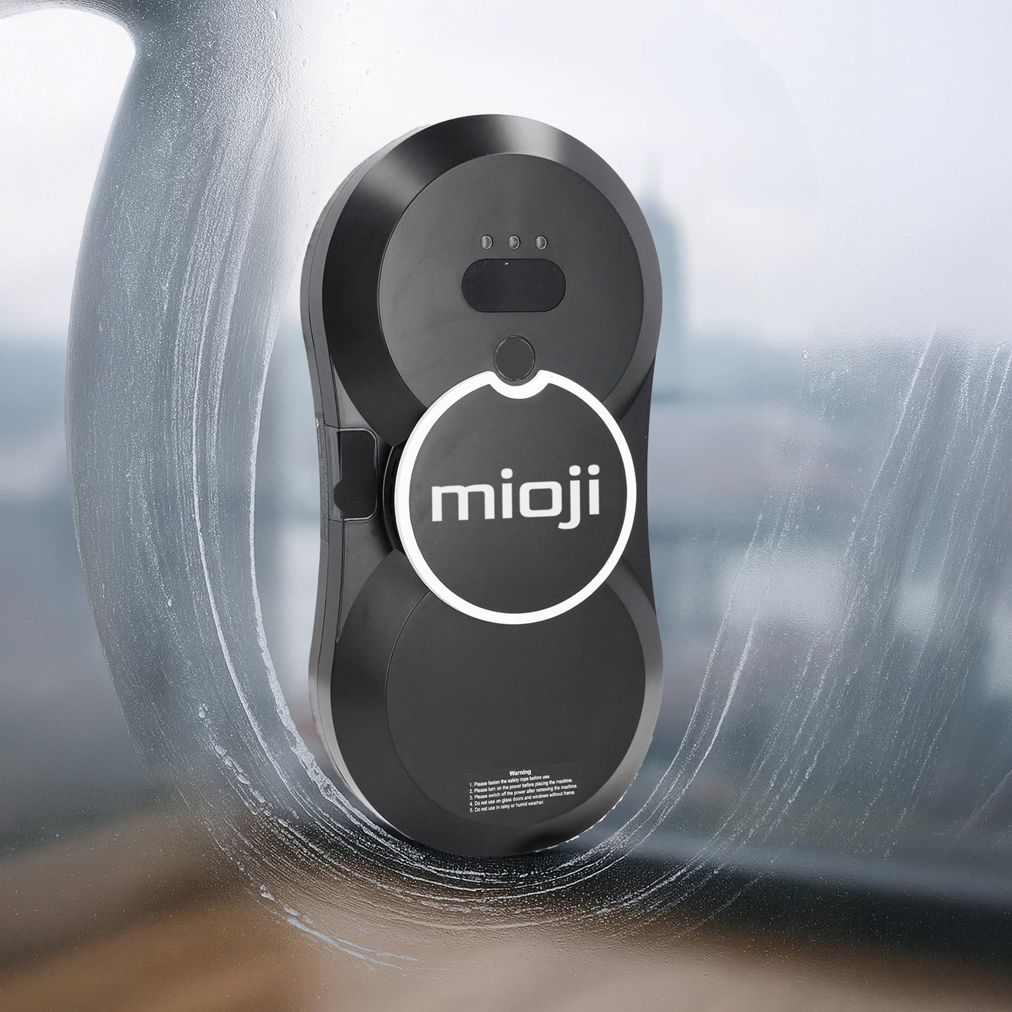 Islak bir pencerede 'mioji' logolu siyah pencere temizleme robotu.