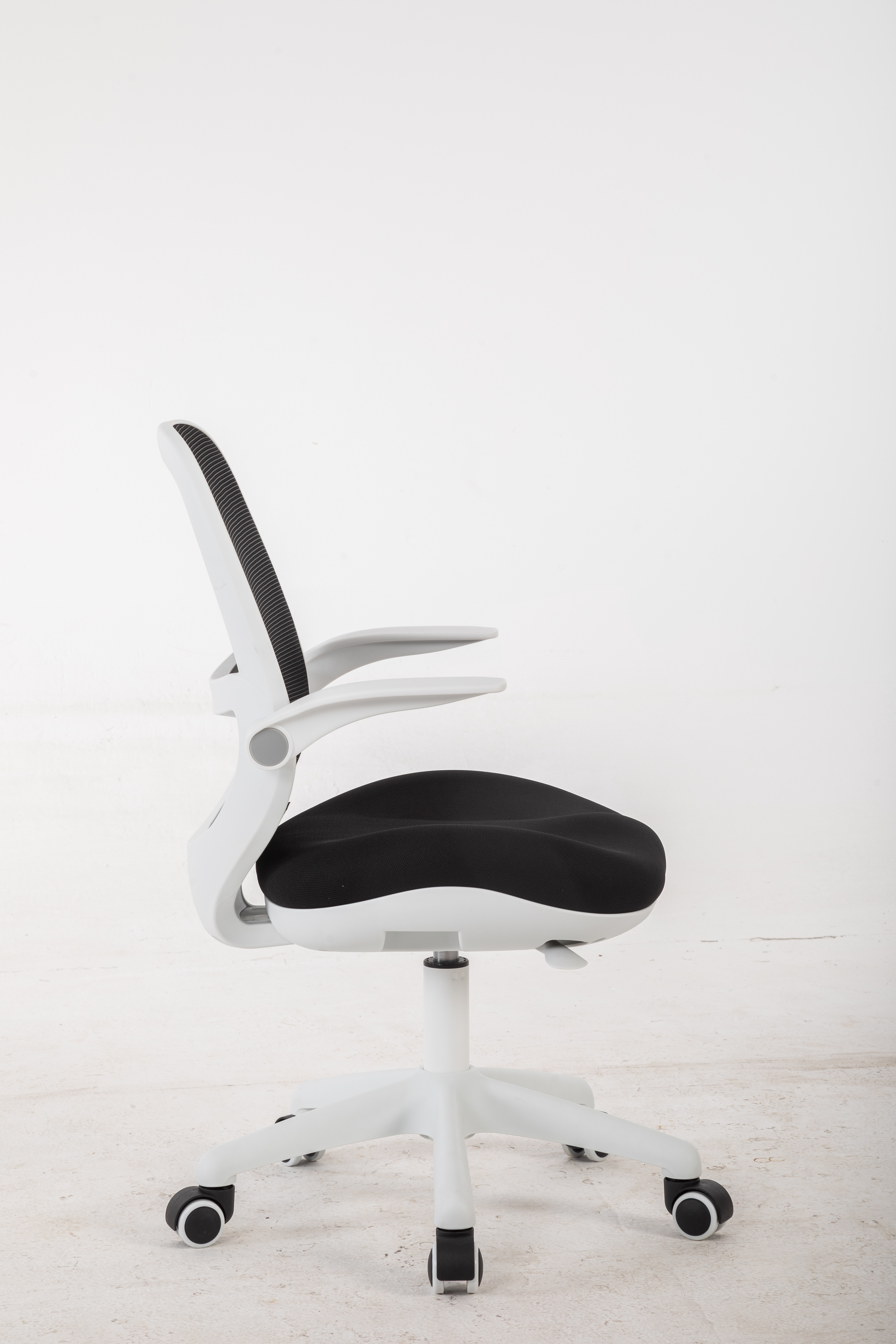 Białe krzesło biurowe z czarnym siedziskiem i siatkowym oparciem stoi na pięciu kołach.
