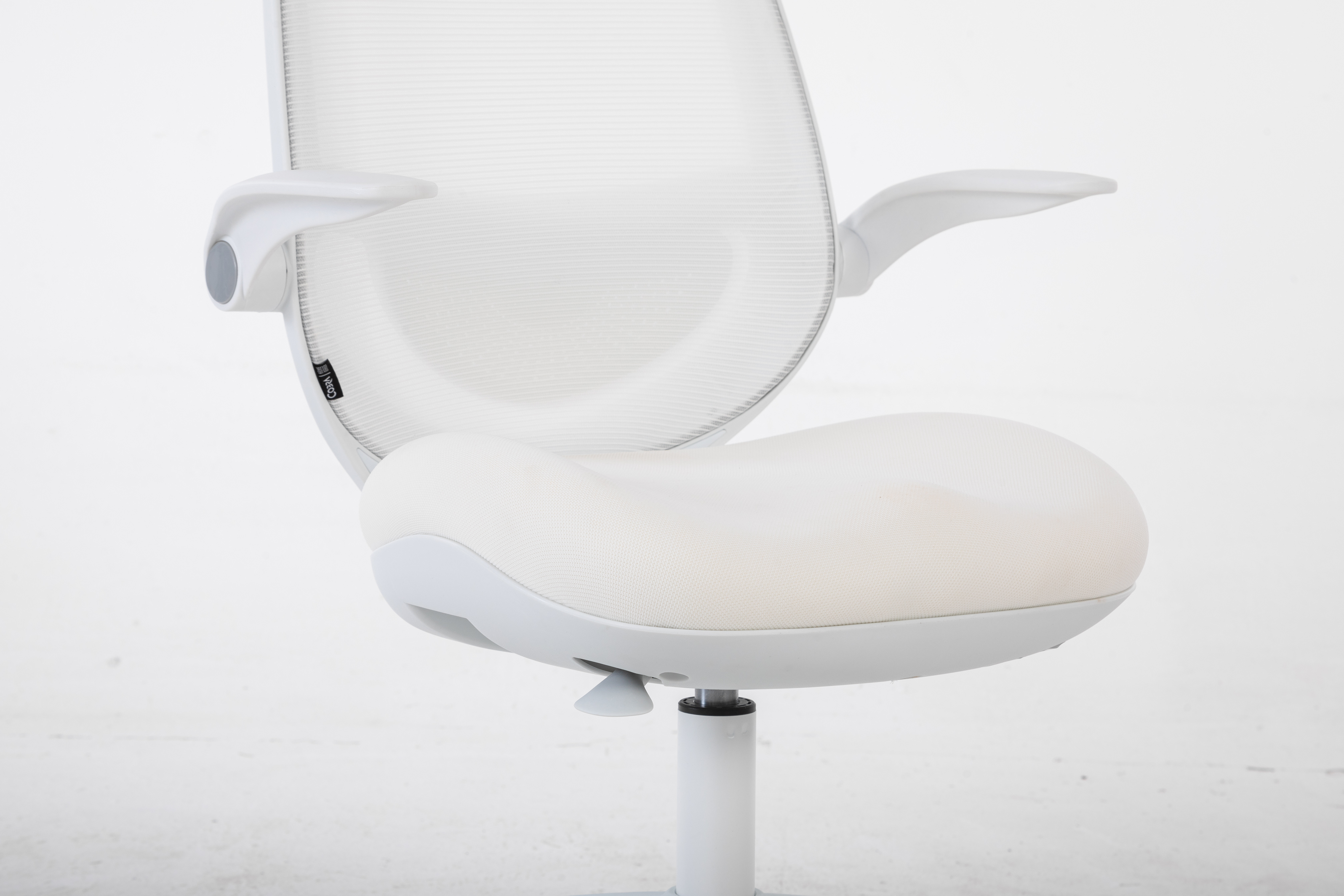 Białe krzesło biurowe z siatkowym oparciem i tapicerowanym siedziskiem.