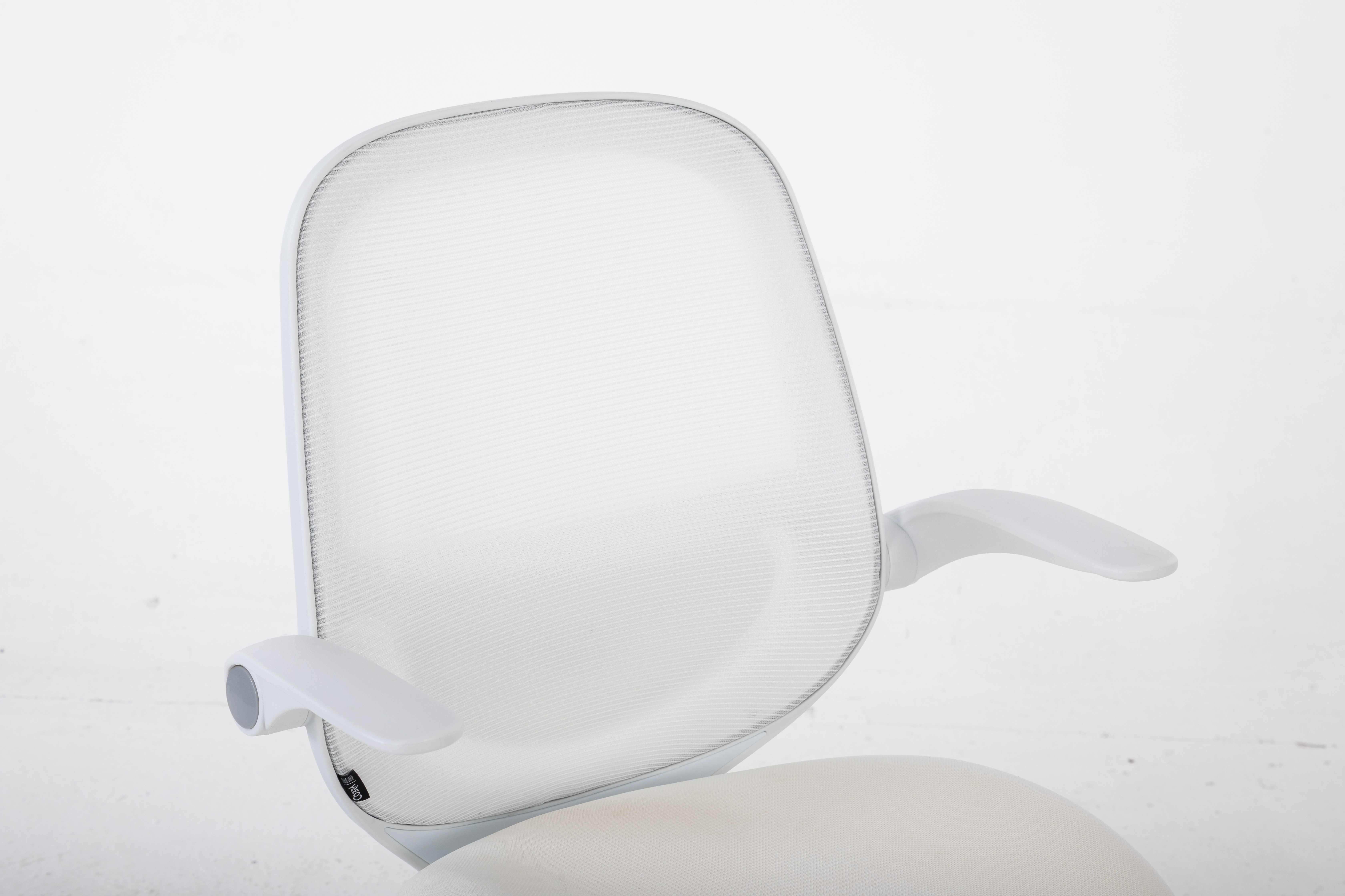 Białe krzesło biurowe z siatkowanym oparciem i podłokietnikami. Siedzisko również białe.