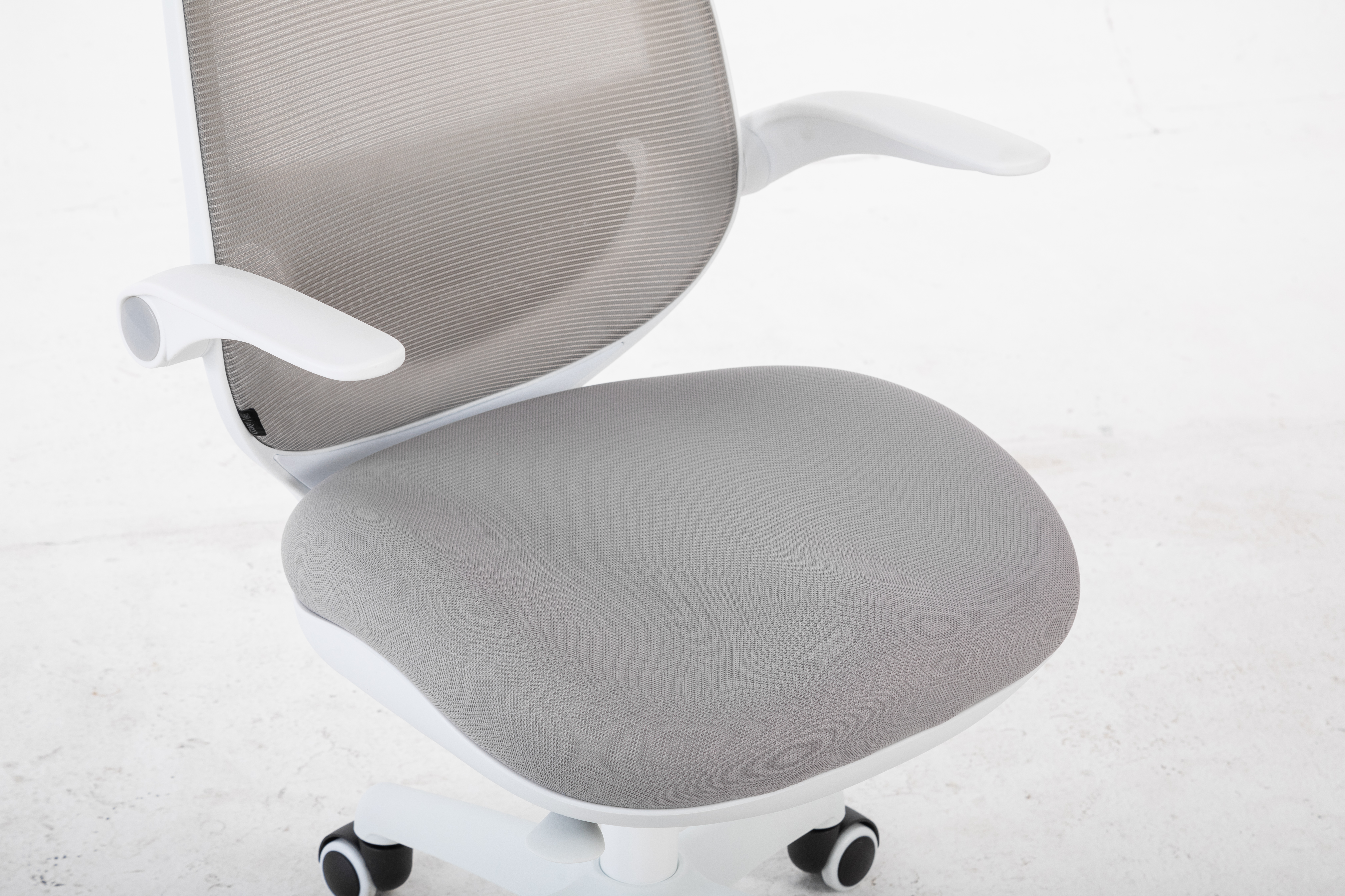 Nowoczesne białe krzesło biurowe z szarym oparciem i siedziskiem z siatki.