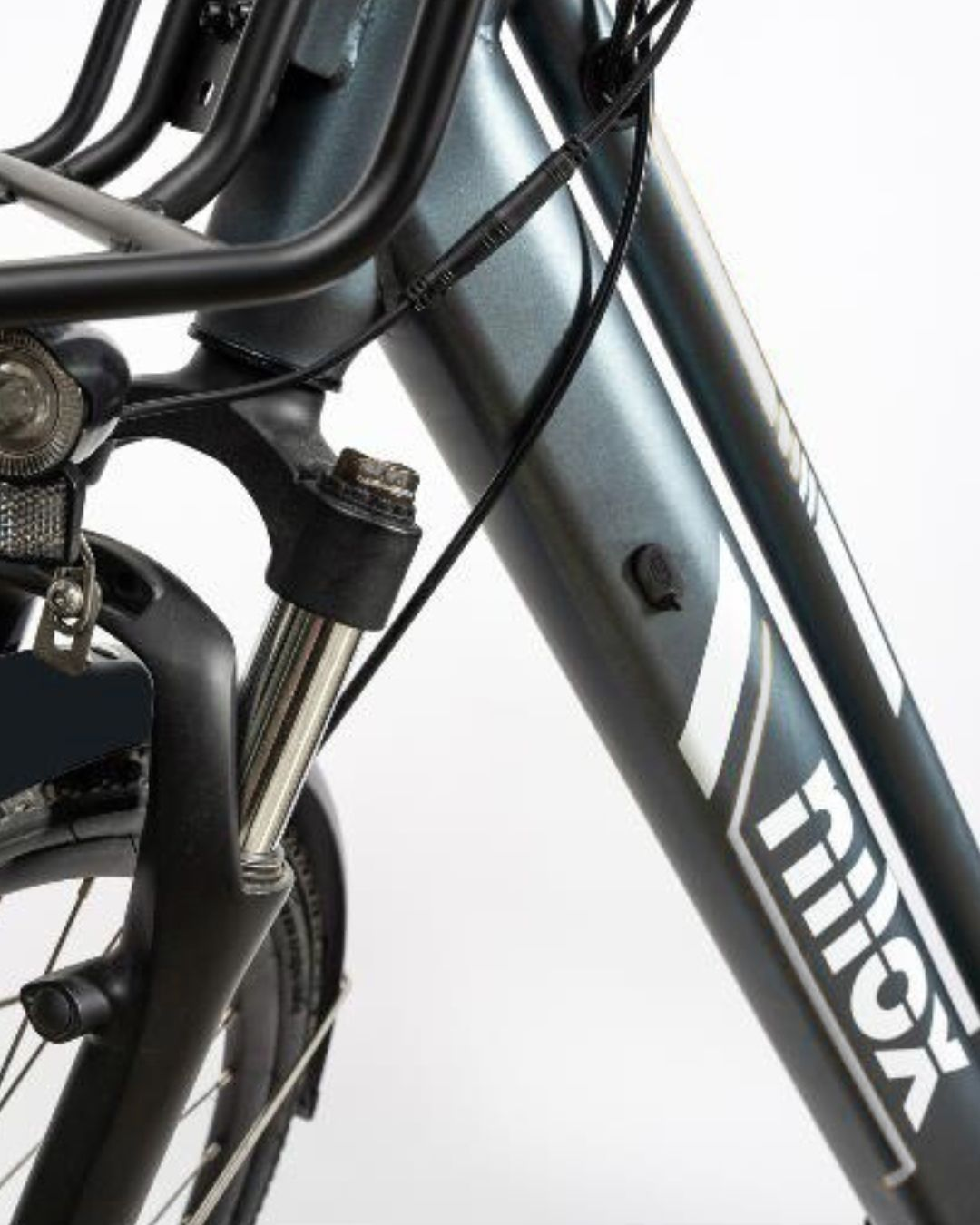 Primo piano del telaio anteriore e della forcella di una bicicletta grigia con cavi.