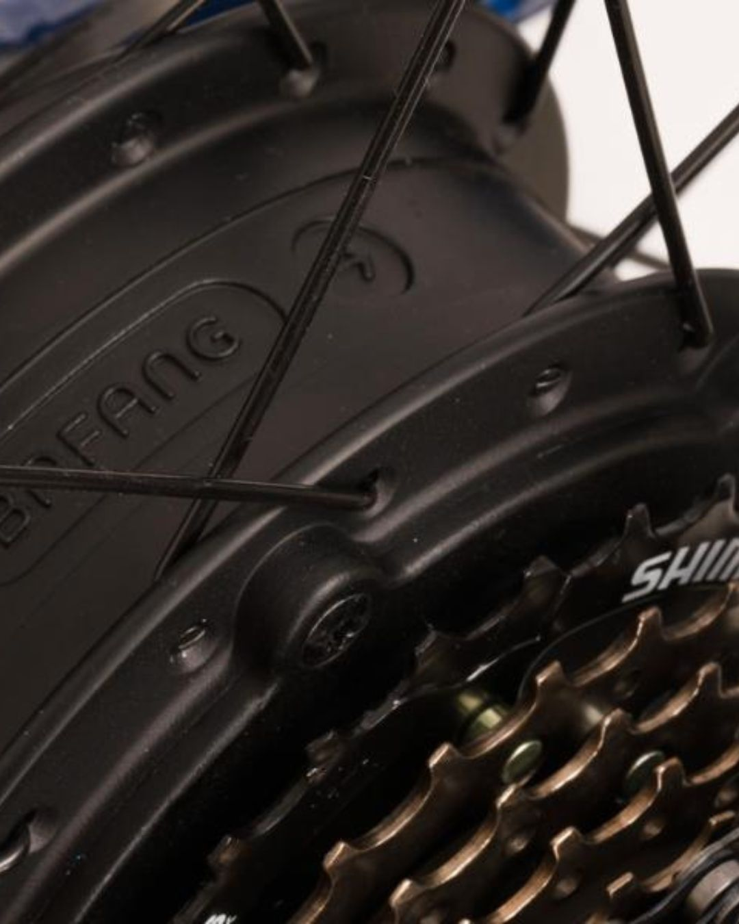 Primo piano di un mozzo di bicicletta nero con raggi e ingranaggi.