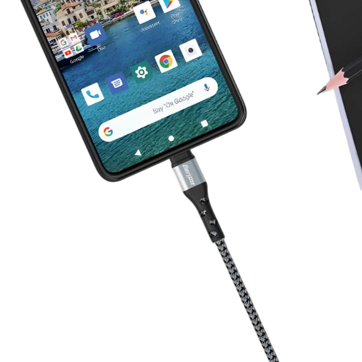 Uno smartphone collegato a un cavo di ricarica, con una matita e un taccuino.